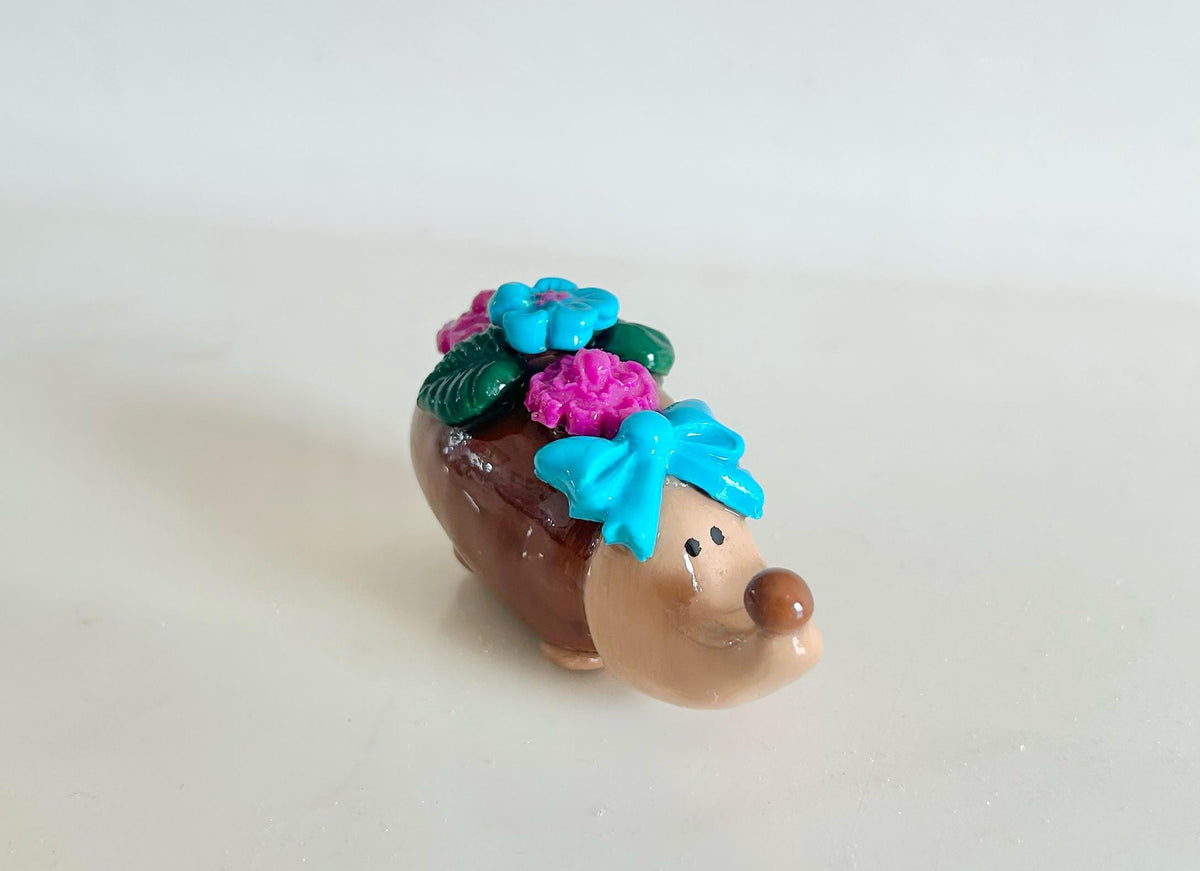 Sculpted hedgehog figurine with flowers