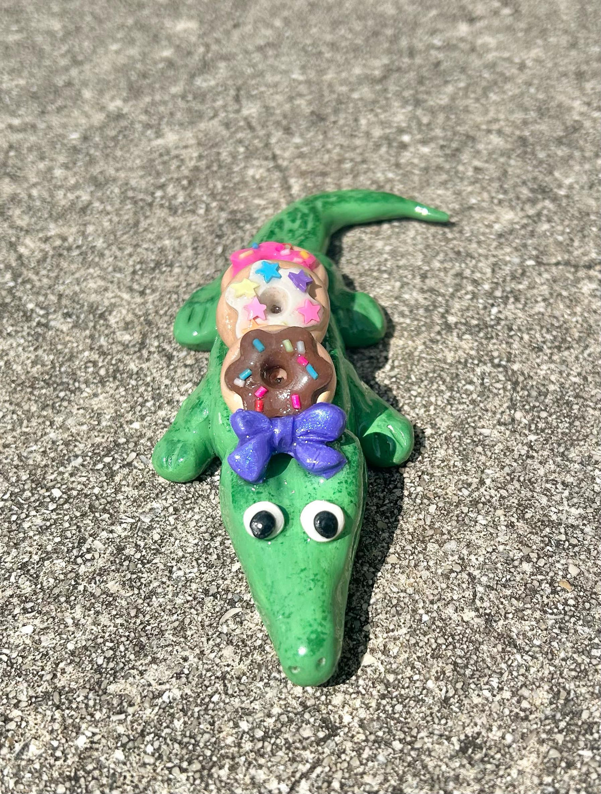 Sculpted alligator figurine with donuts