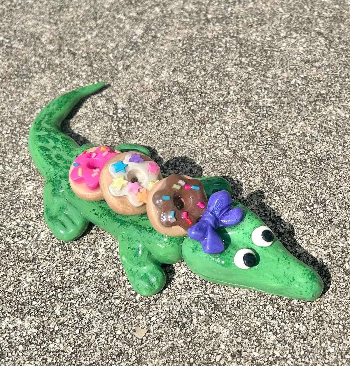 Sculpted alligator figurine with donuts